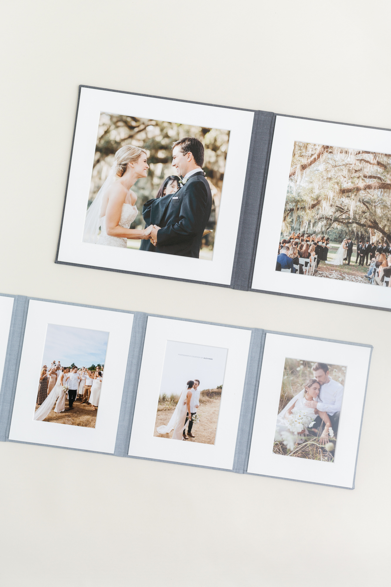 Two open matted folios showing wedding prints in white mats with grey and blue linen covers