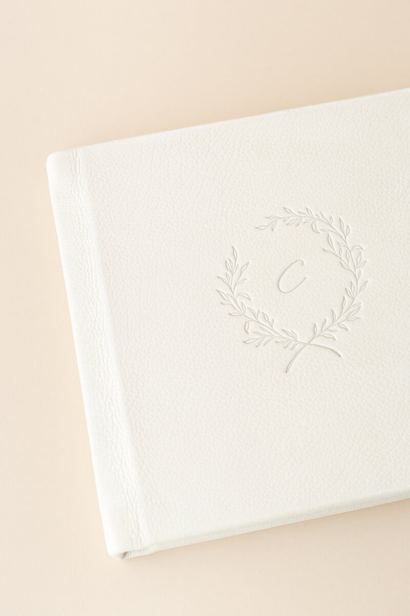 Cream leather fine art album with debossed wreath monogram