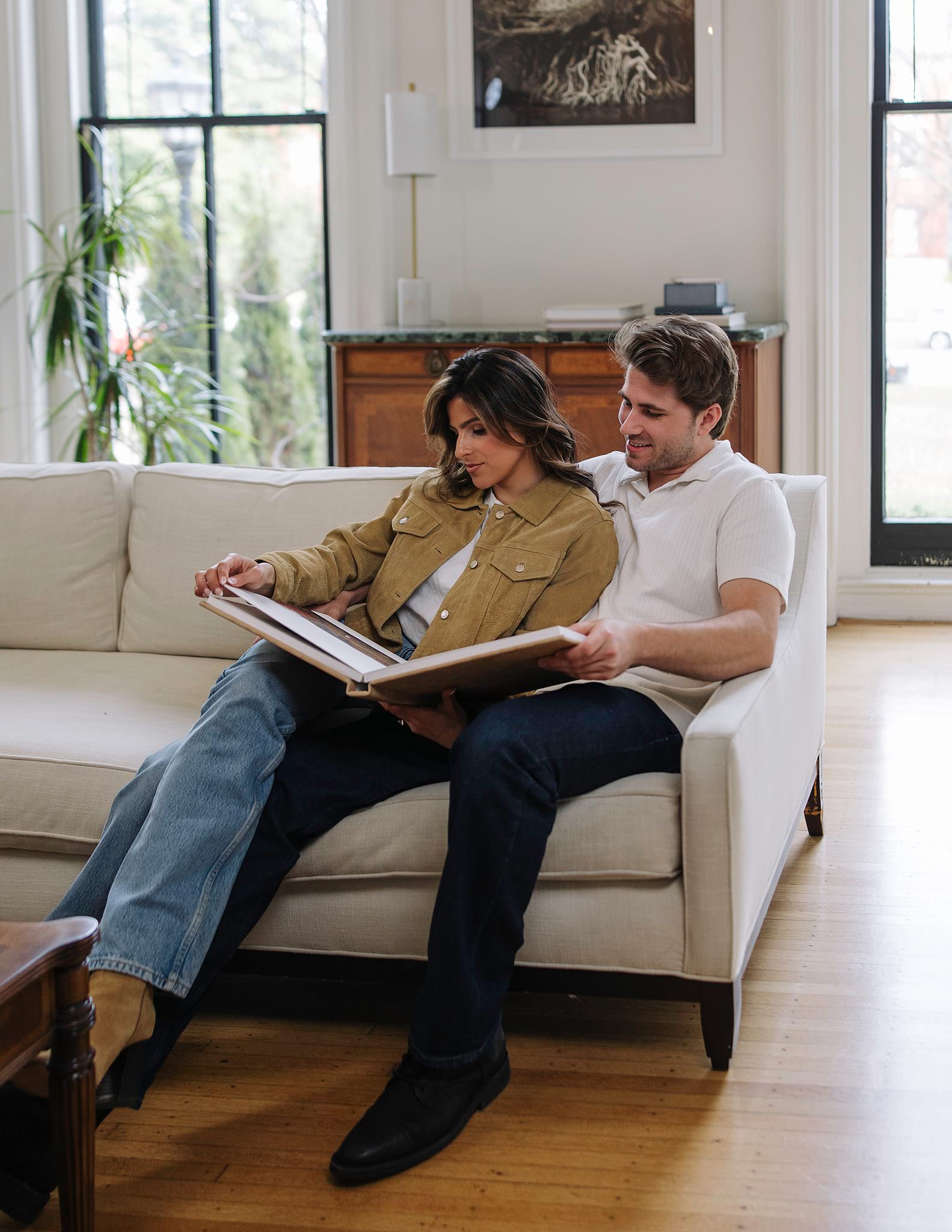 A couple together on a couch with a RedTree Album